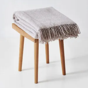 Night & Day Melange uldplaid i farven latte på taburet